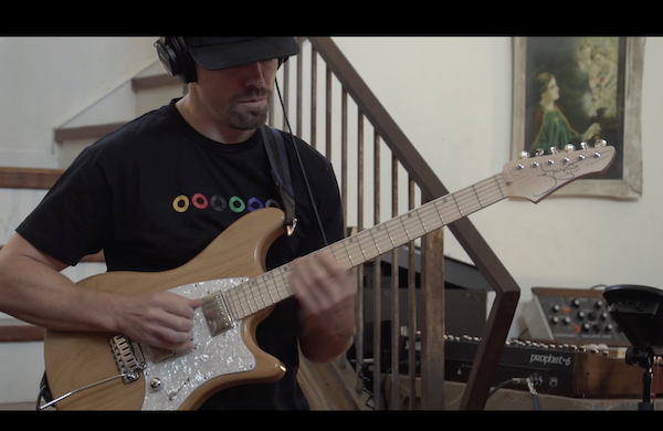 Matt Muehling shredding so fast on his signature John Page guitar that his left hand is blurry