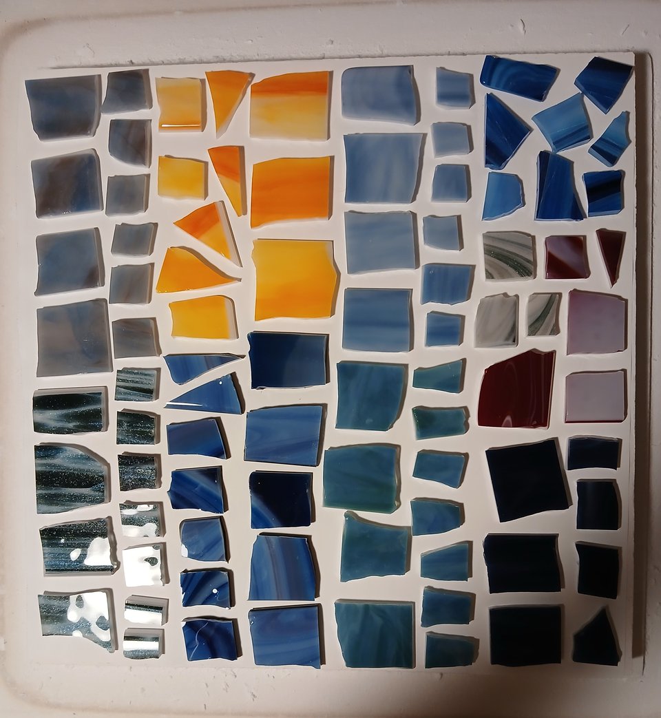 kiln shelf with glass pieces in blues, yellows, greens and reds