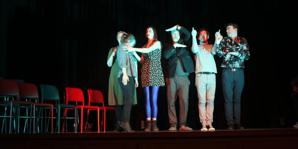 Six improvisers on stage in a line.