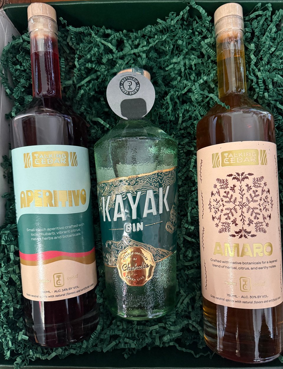 bottles of Talking Cedar spirits Aperitivo, Kayak Gin, and Amaro