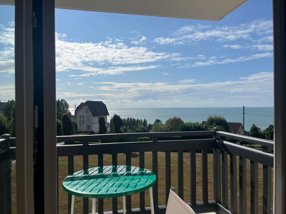 A view of the sea from a window up a hill