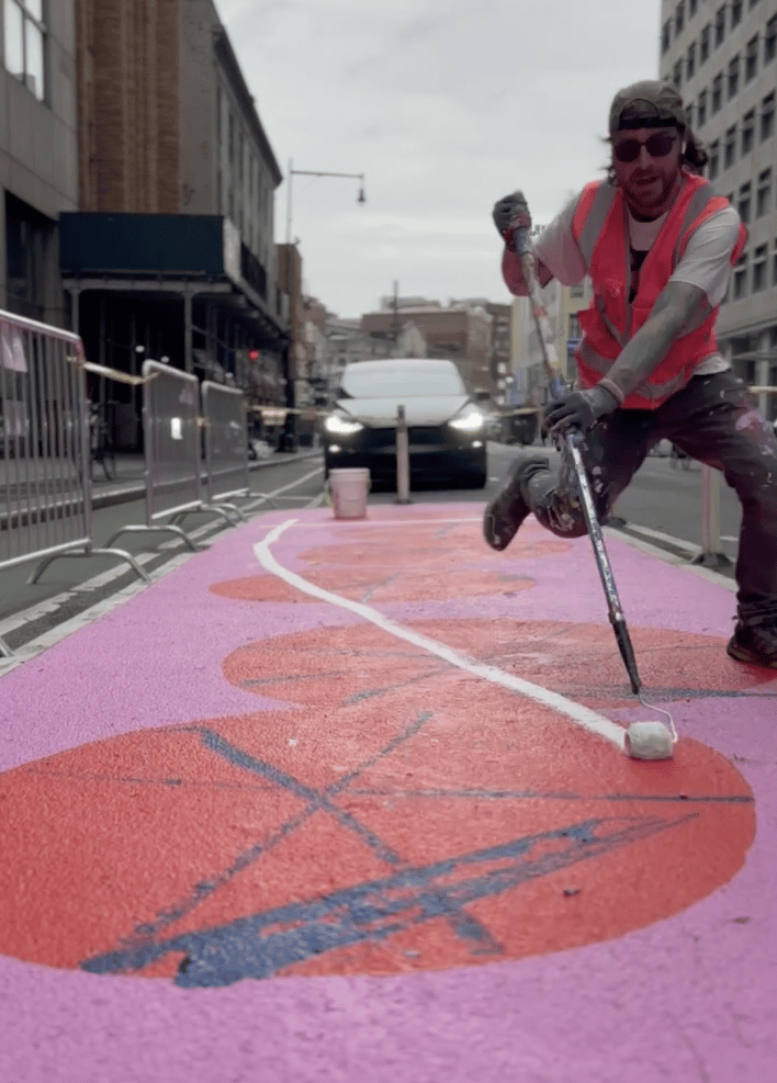 BOICUT painting an asphalt mural in NYC