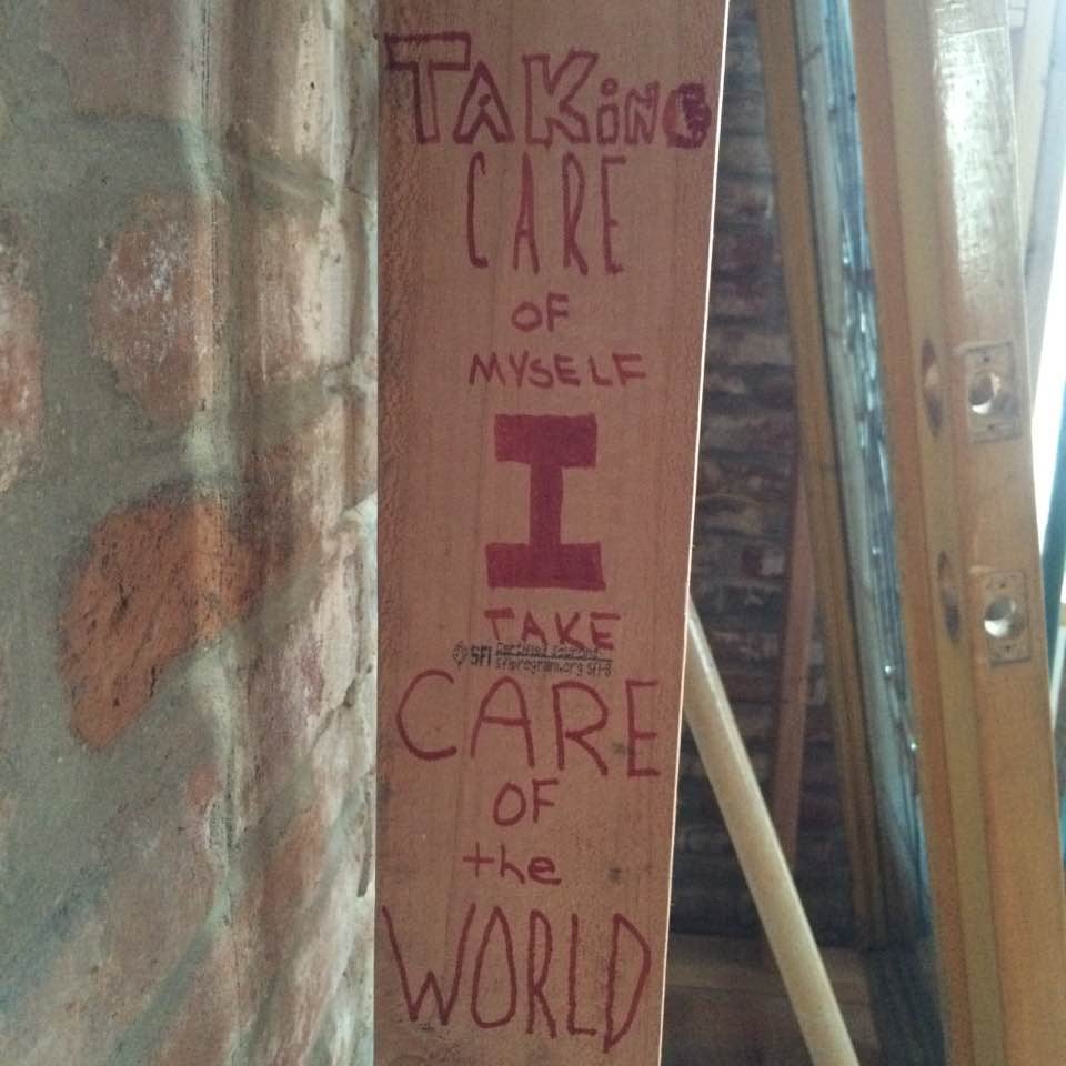 When we built Human Spaces we put poetry, stories and concepts in the walls. This is part of the wall framing with the words "Taking care of myself I take care of the world" on it in red marker.
