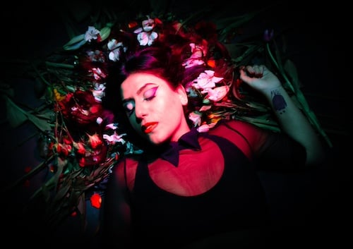 a woman lying on a bed of flowers