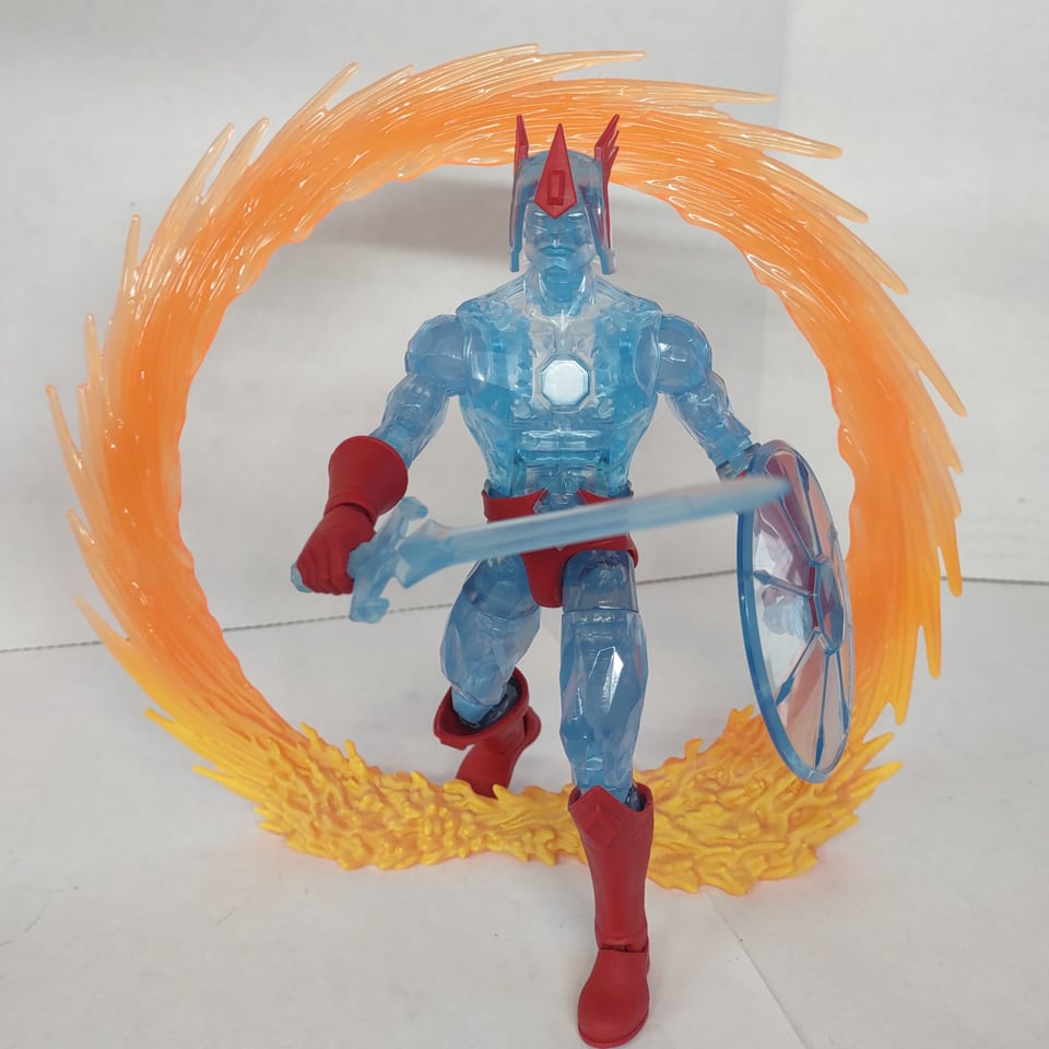 A translucent blue "crystal" action figure with red boots and gloves holds a sword and shield (also "crystal") as it steps through one of Doctor Strange's spinning portals.