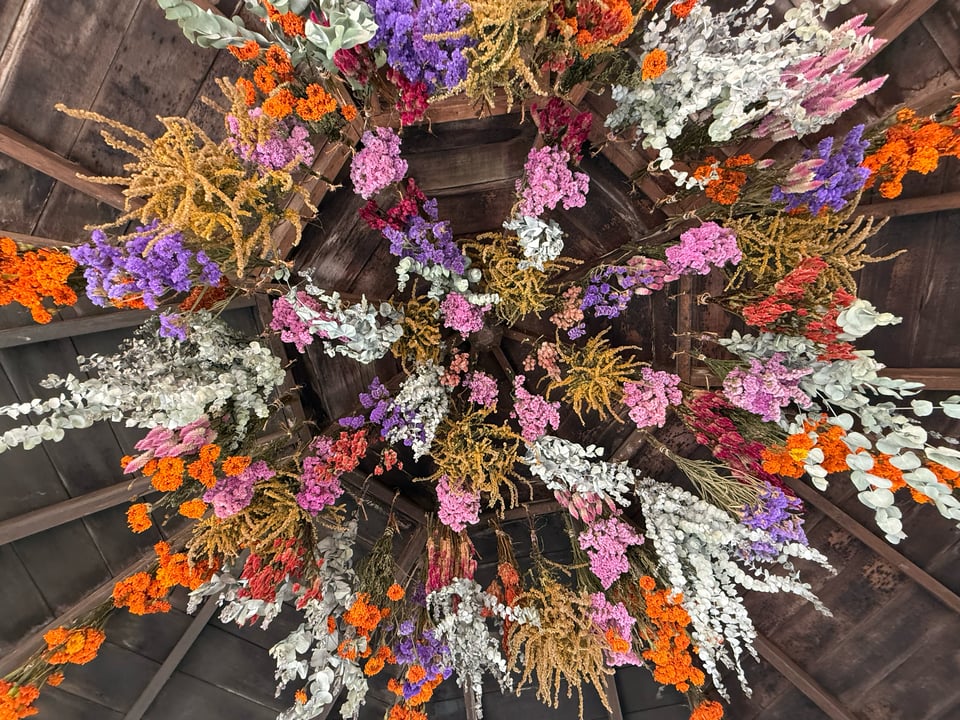 An ornate arrangement of flowers on the interior roof of a gazebo