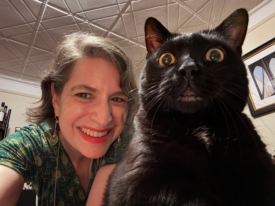 Amanda Schuster poses with adorable black cat