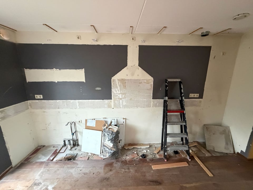 The remains of a destroyed kitchen. The paint on the walls shows the empty spaces where the kitchen used to be.