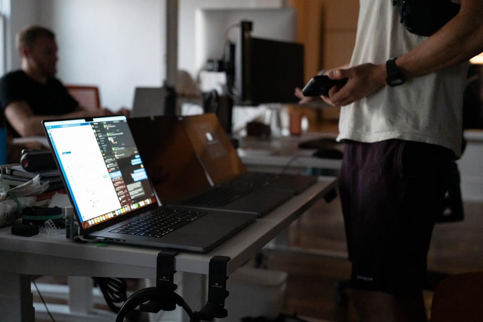 Drew looking at three laptops.