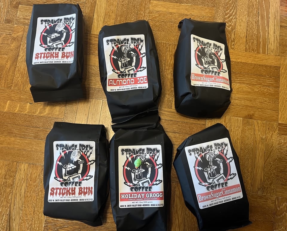 Six black bags of coffee with a cool robot label indicating they're from Strange Brew Coffee