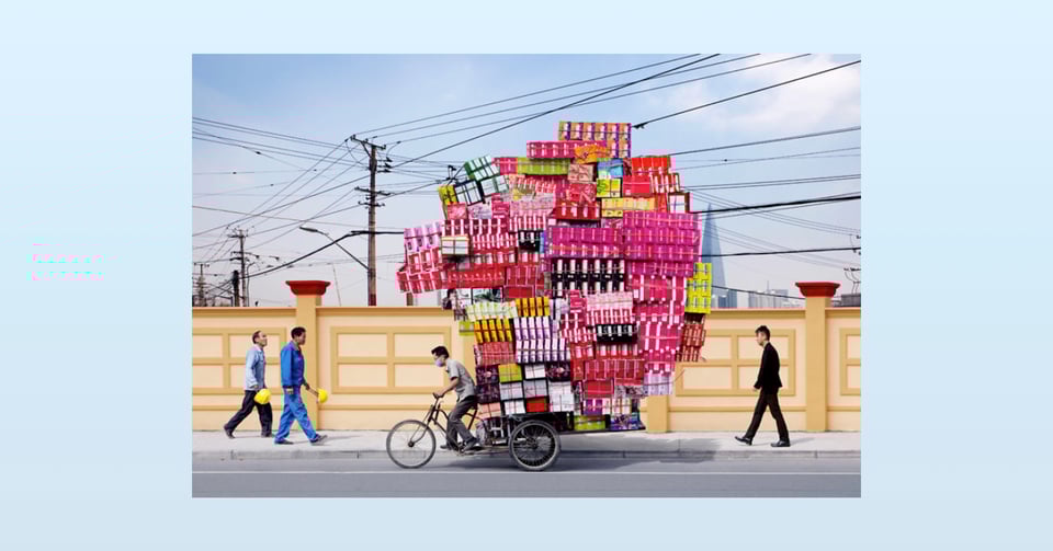 A picture of a bicycle overloaded with boxes.