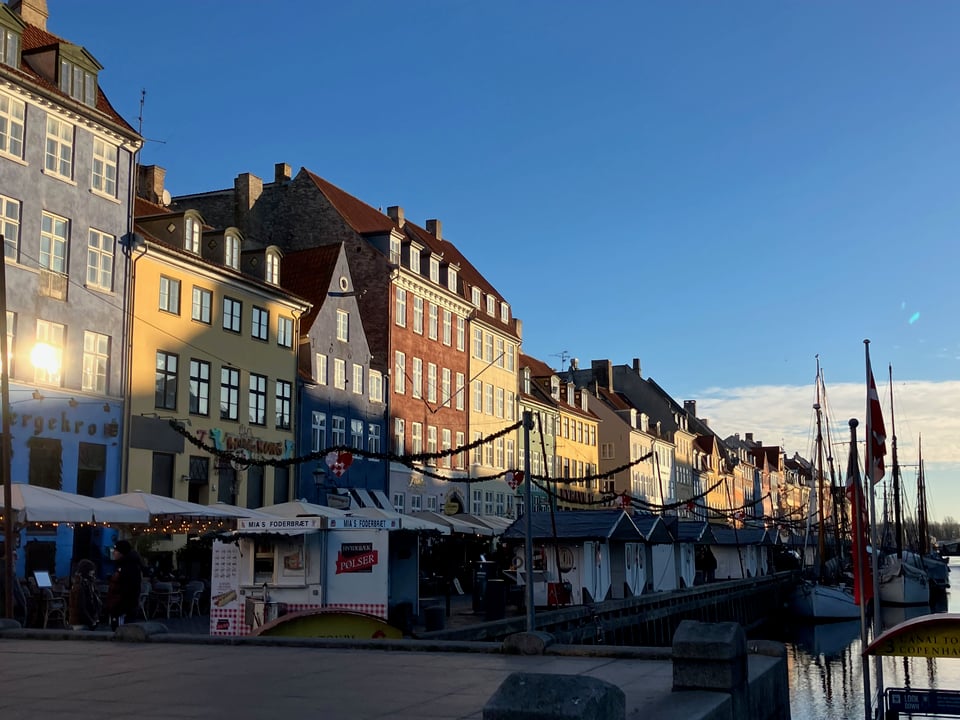 Row of painted buildings, half in shadow.