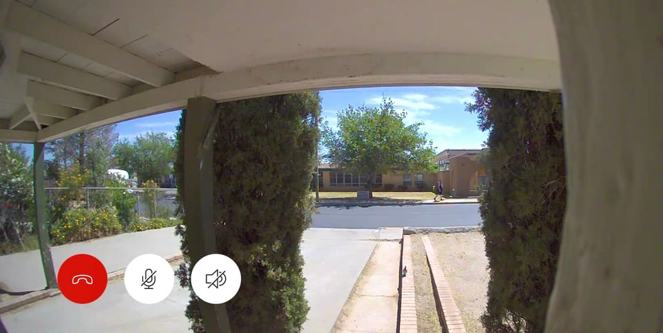 A partial view of Hacienda Heights Elementary across the street from the porch as seen from the doorbell camera. Two pines trees block part of the view.
