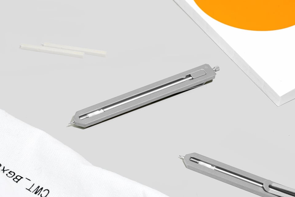 two Pencil Type-C lying on a table next to a book and bag