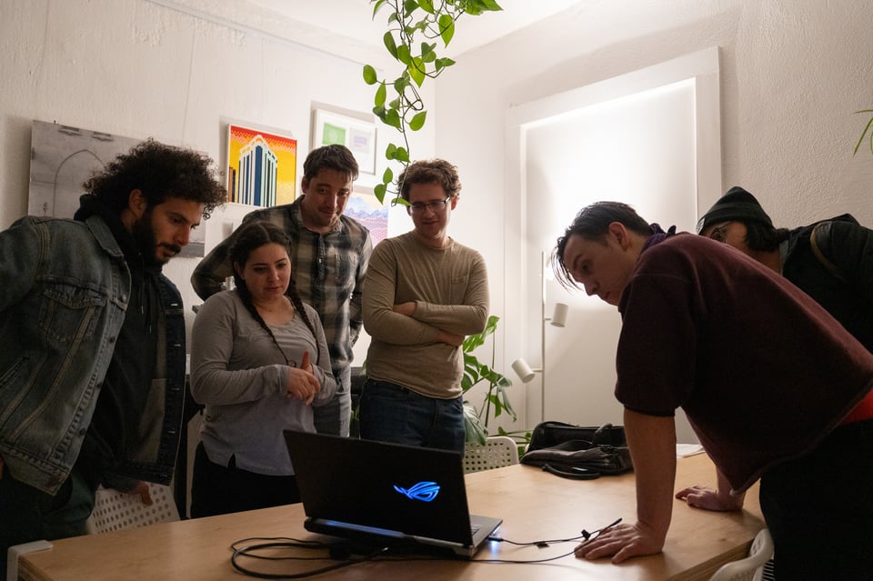 A group of people looking at a computer screen.