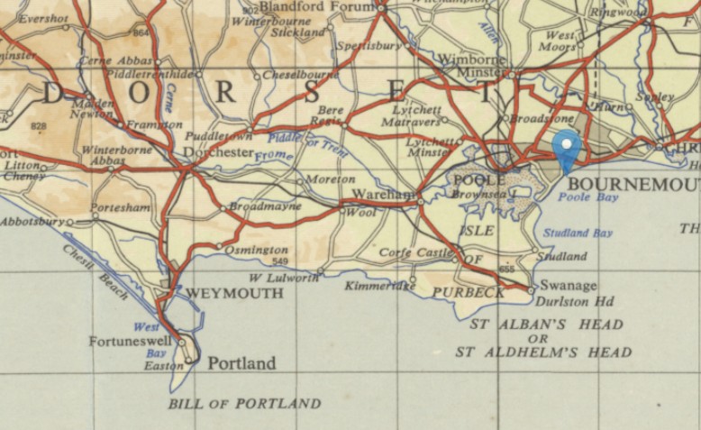 A brownish map of Dorset and Hampshire, showing Poole and Bournemouth to the east. A map pin has been dropped where the old county line reaches the coast in between the two towns.