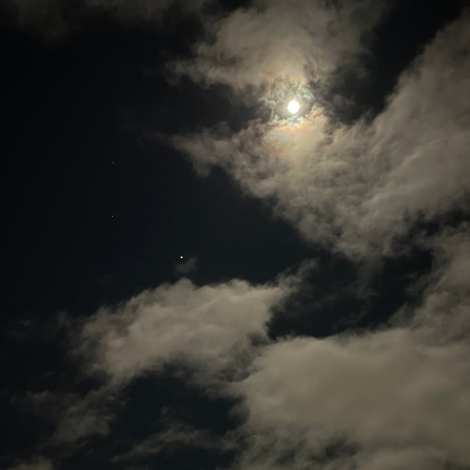 image of the full wolf moon in january and some surround stars and planets