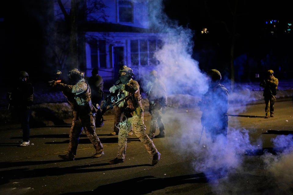 Federal immigration officers shoot pepper balls as tear gas is deployed at the scene of a reported shooting, Jan. 14, 2026, in Minneapolis
