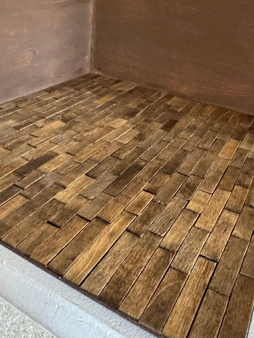 a miniature floor made out of popsicle sticks