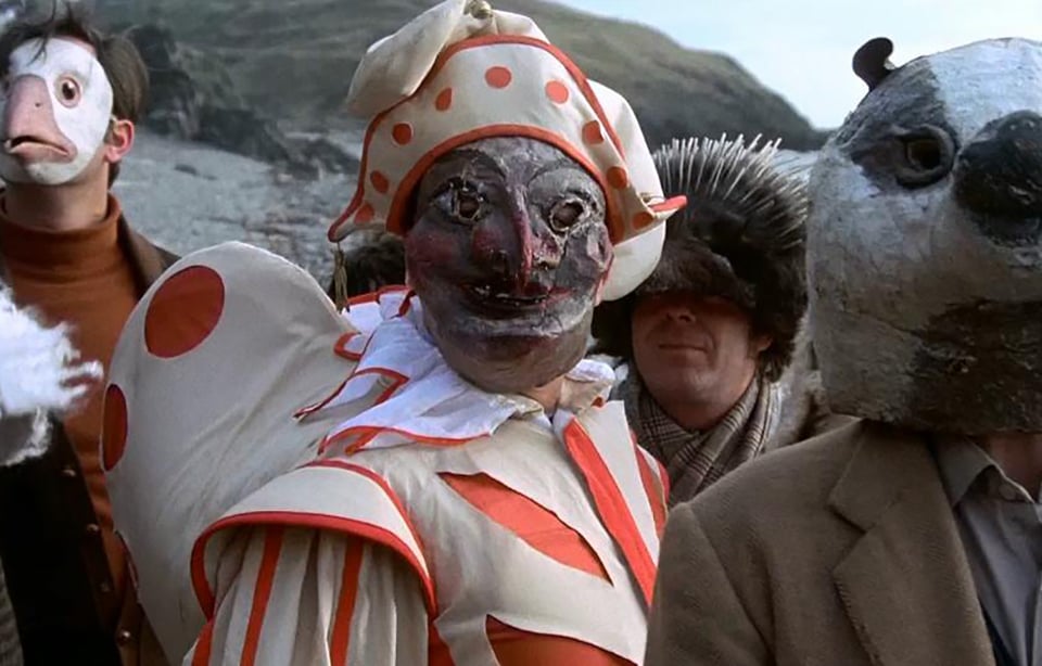 A scene from The Wicker Man (1973) featuring characters in costume dressed for the community's May Day celebration.