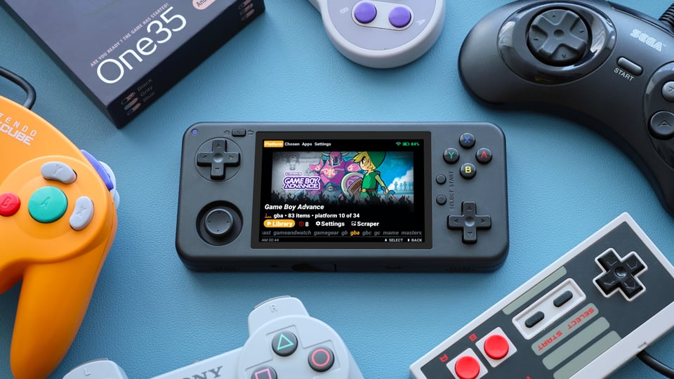 a group of game controllers surrounding a retro gaming handheld