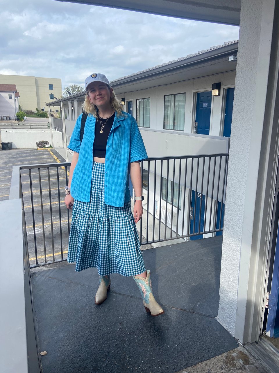a woman wearing a blue jacket and striped skirt