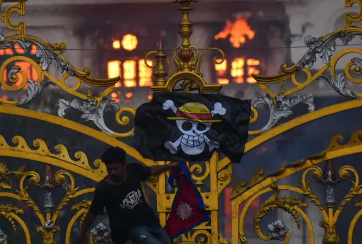 Amazing shot of a Nepalese protester outside the gates of parliament with a Luffi from One Piece pirate flag