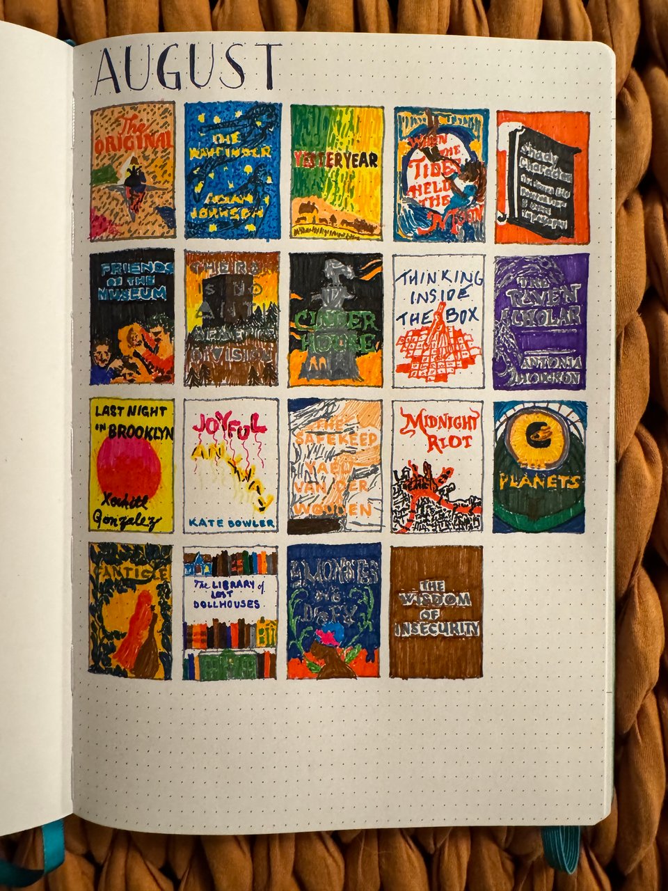 A dot-gridded journal page titled "AUGUST" with a grid of 19 hand-drawn book covers, each representing a book, with titles and illustrative elements.