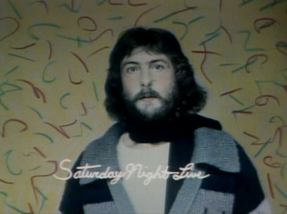 a man with a beard in front of a colorful background