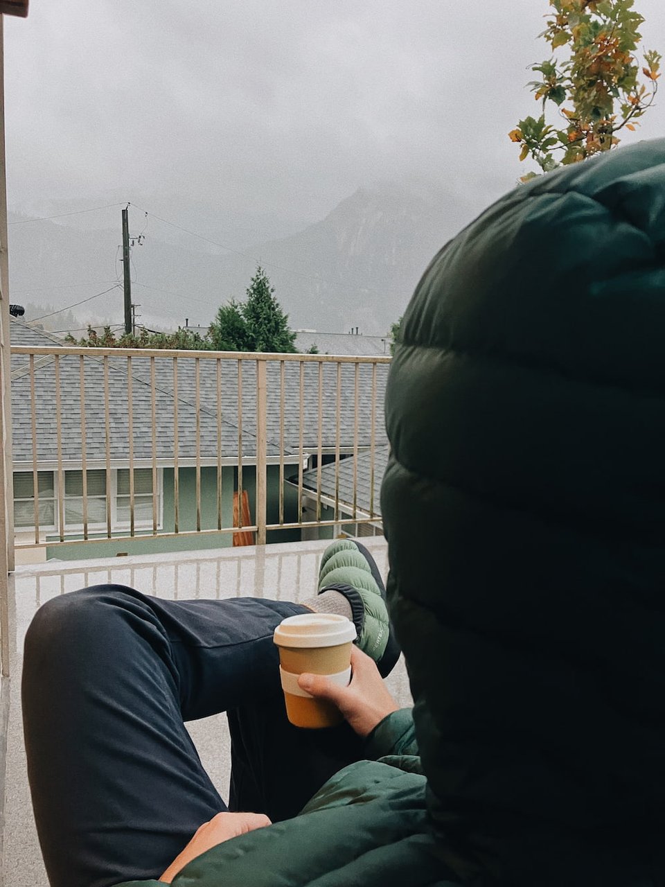 me sitting in a small camp chair, coffee in hand, barely out of the rain, watching it fall among the distant mountains