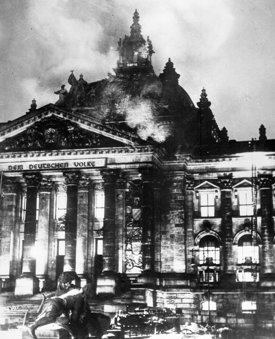 a black and white photograph of the Reichstag, consumed in flames
