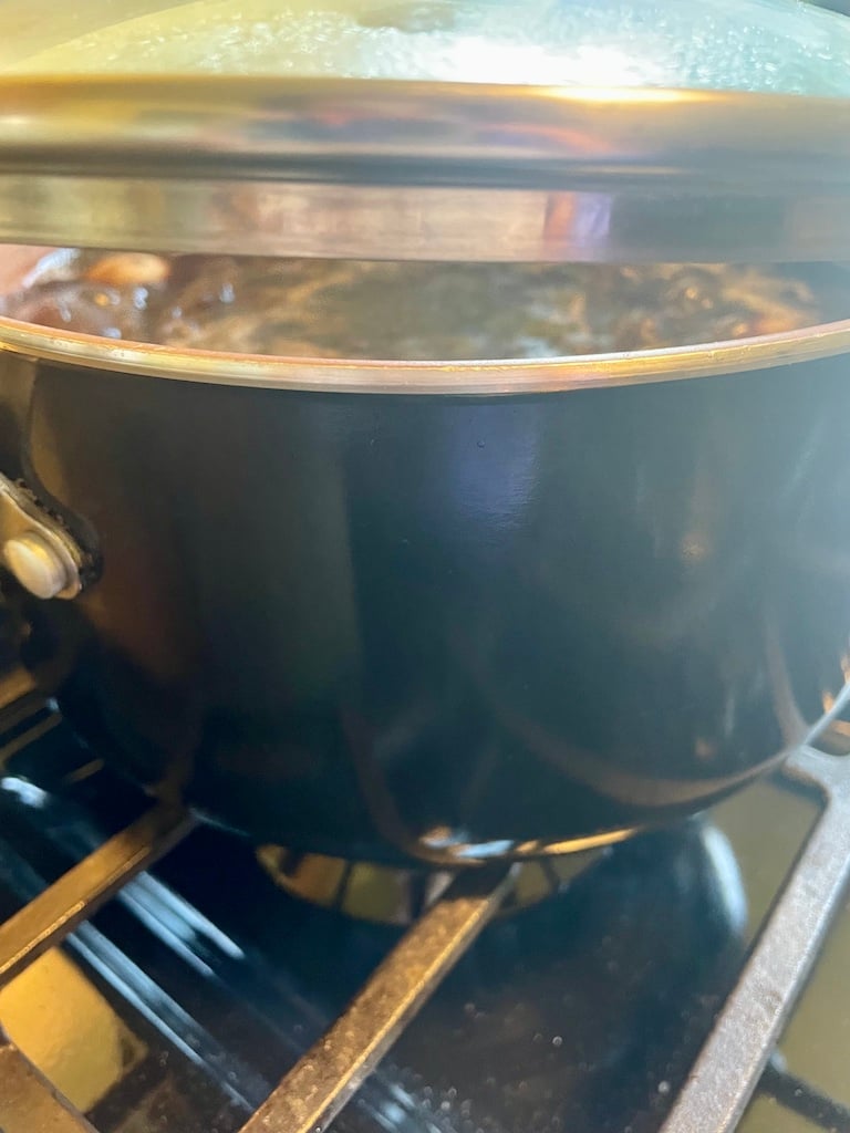 A partially-lidded pot of beans
