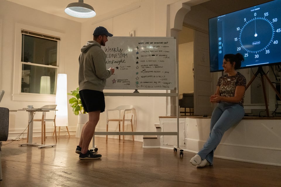 Andrew checking off a goal from a whiteboard.