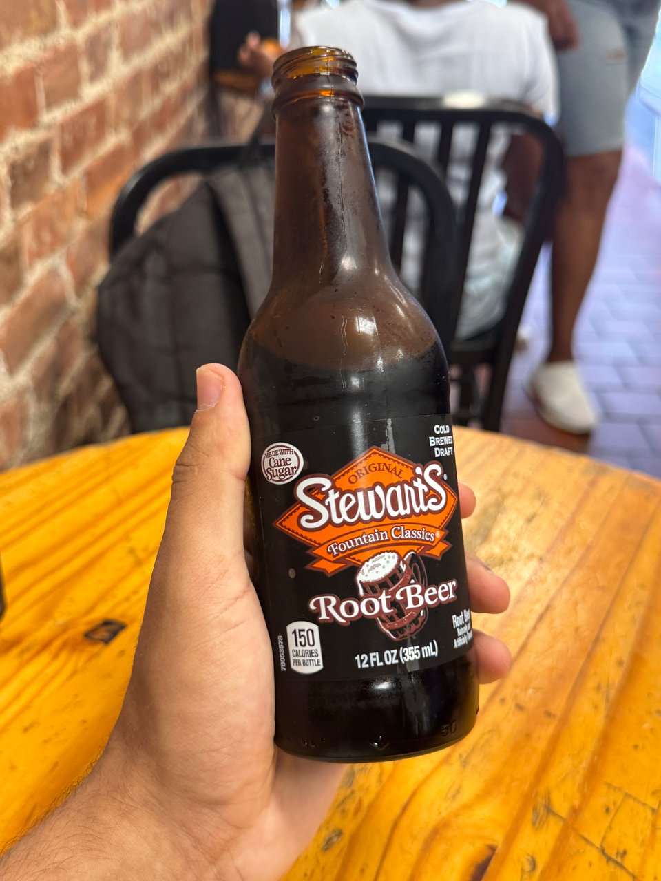 My hand holding Stewart's fountain classics cane sugar root beer.