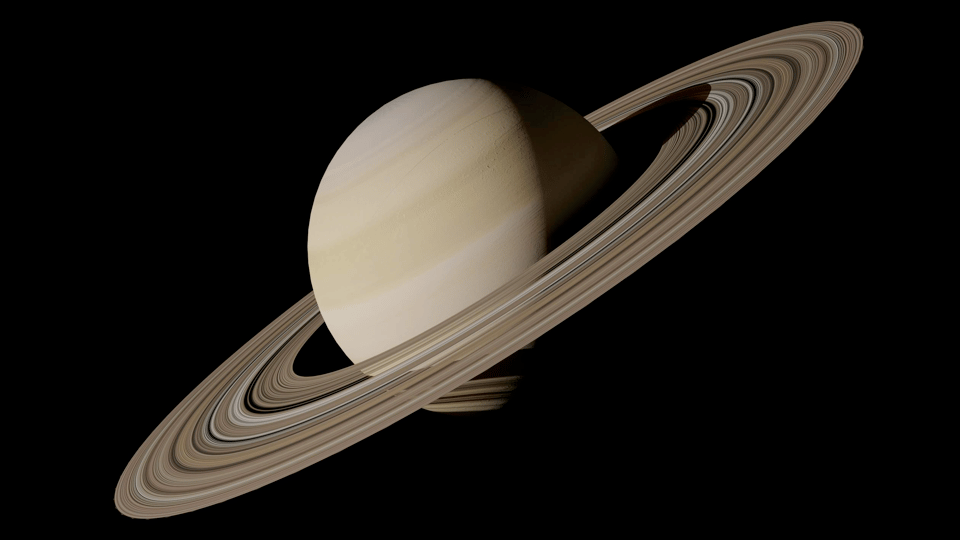 A close-up photo of the planet Saturn. Its large rings are tilted slightly towards us and are angled at 45 degrees sloping diagonally downward to the left. It is brightly lit against a black background.