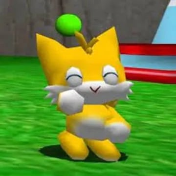 A yellow, child-like creature designed after Tails from Sonic the Hedgehog. It has yellow fur, a white stomach and mouth/whiskers, a green ball floating over its head, and is raising a fist towards the camera with a delighted expression on its face.