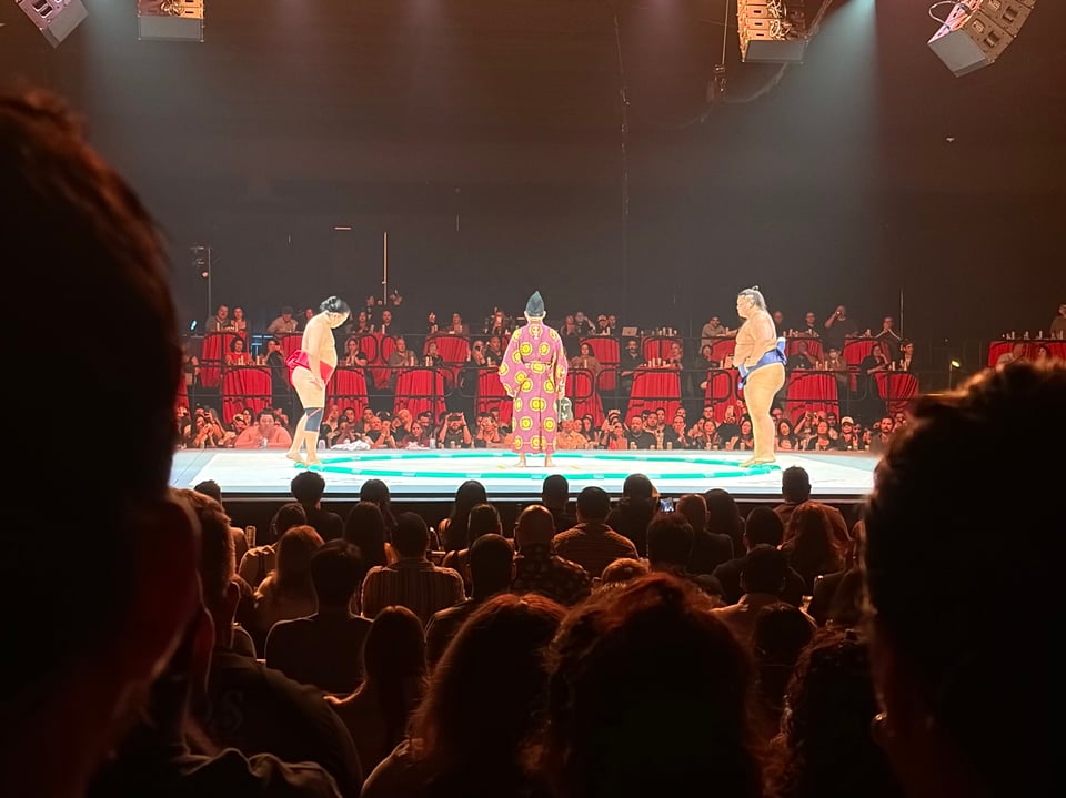Sumo wrestlers Meccha and Ohtani with a referee on stage at Sumo + Sushi in Los Angeles