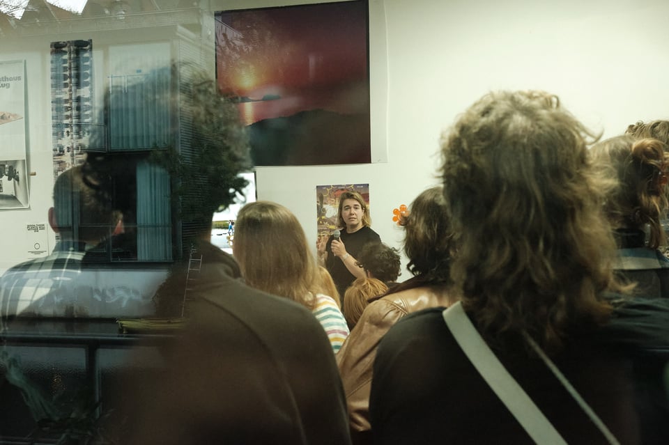 Speaker Janna Bystrykh seen through the gaps between the backs of audience members