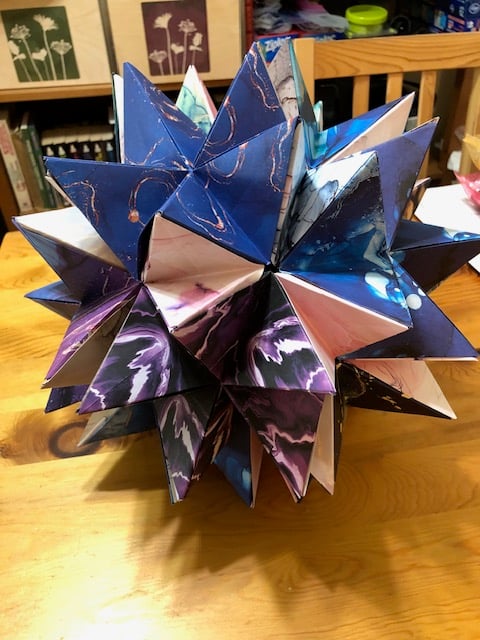The same origami model, but now opened to reveal it is made of brightly colored origami flowers