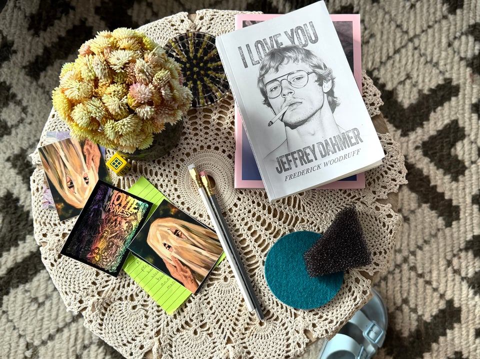 side table piled with stickers, pencils, books and flowers