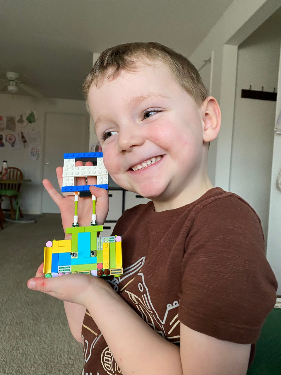 a young boy holding a lego toy