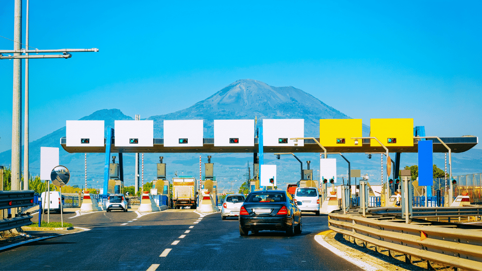 Photograph of cars approaching a line of toll booths across a road.