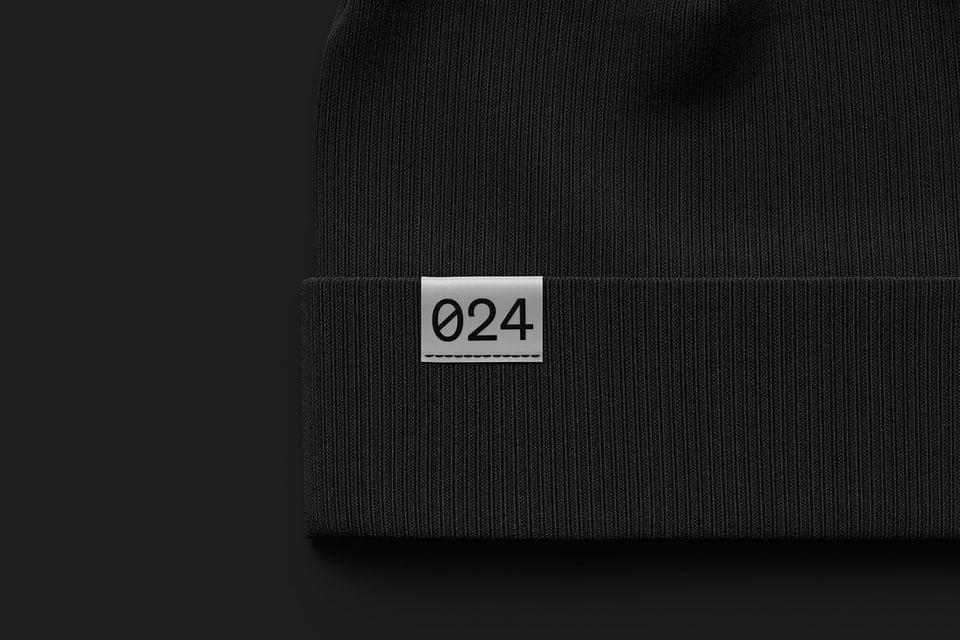 Cropped close up view of a black beanie with a label stating 024