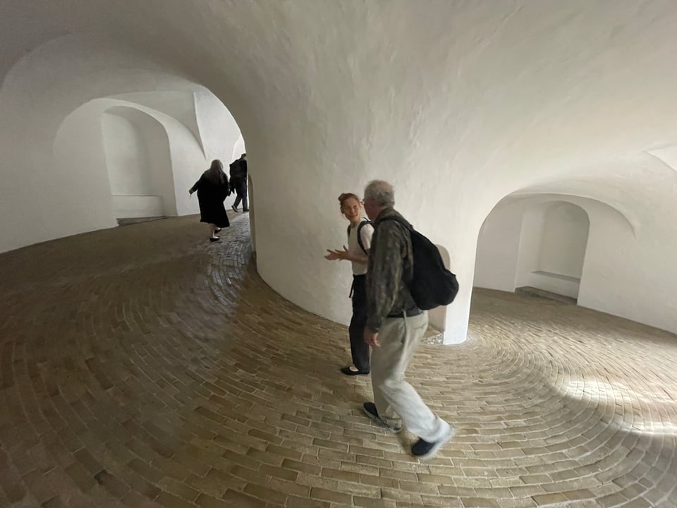 Four people in two groups of two walk up the ramp of the tower to eventually get to the top.