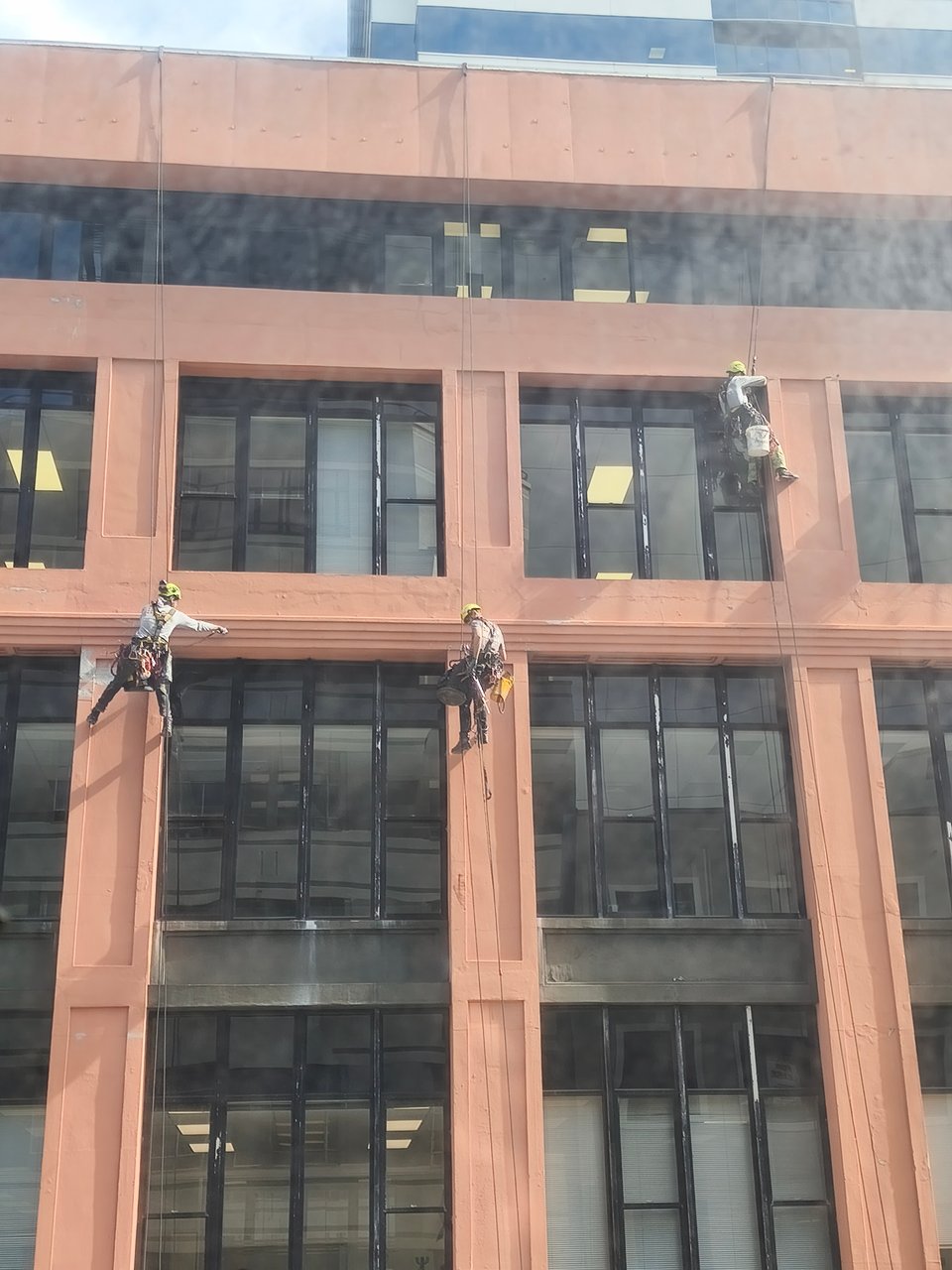 workers dangling off an 8 story building