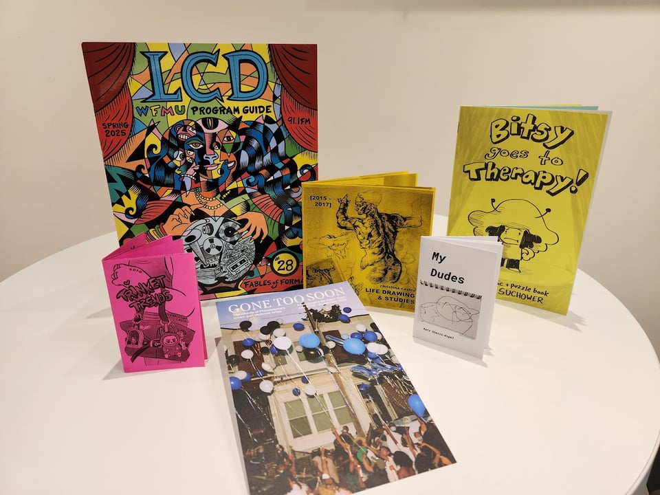 Zines made from paper of various sizes and colors arranged on a table.