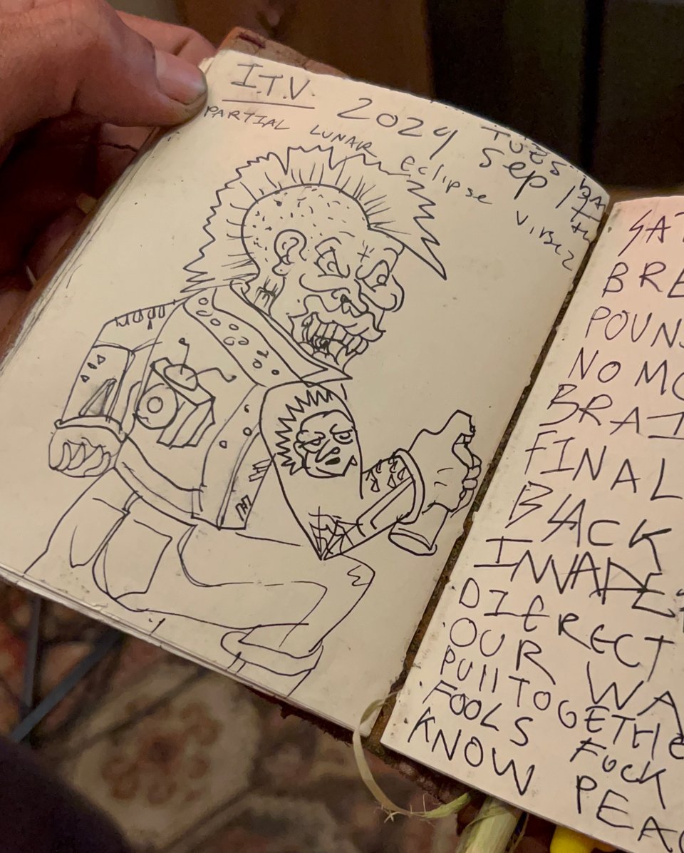 sketchbook page of a punk skull dude with a mohawk holding a spray can