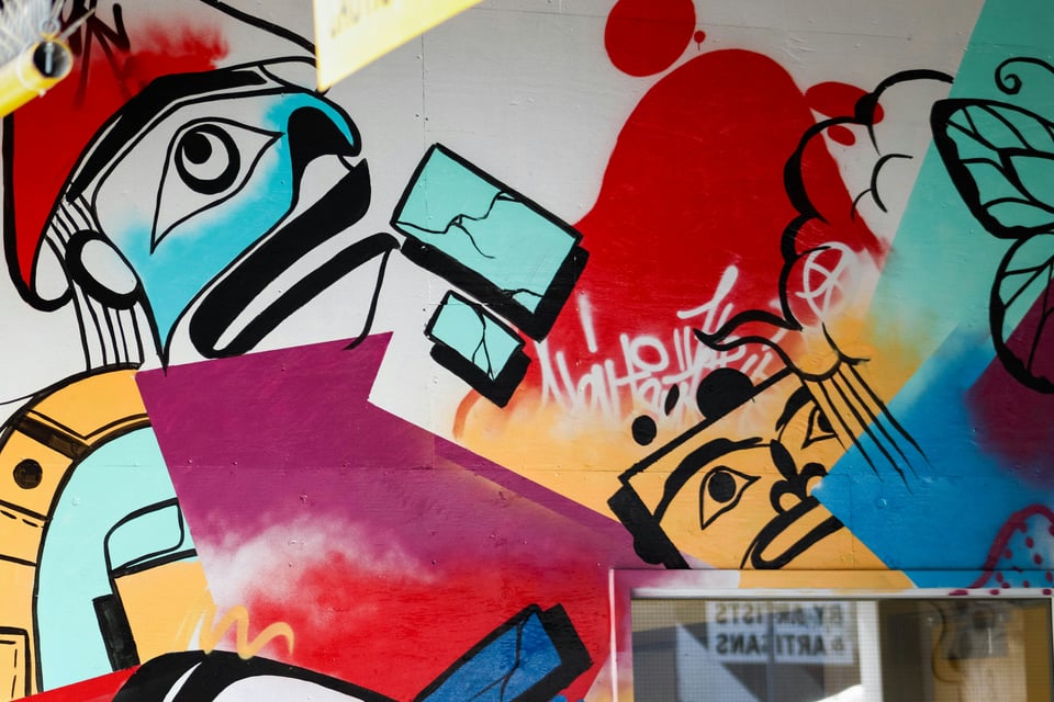 Photo of a colorful mural with elements of Indigenous line form artwork