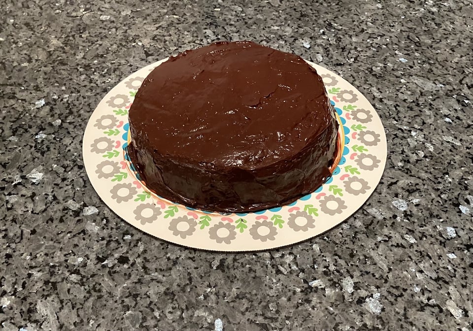 A chocolate chip cake covered in chocolate frosting, with two thin layers. Baby nephew had a taste of the frosting and approved.