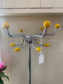 a chrome coatrach with yellow tips at the end of the prongs you hang things on